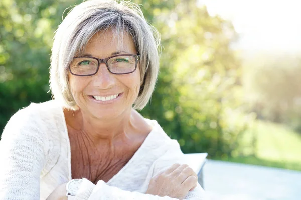 woman with eyeglasses relaxing outside