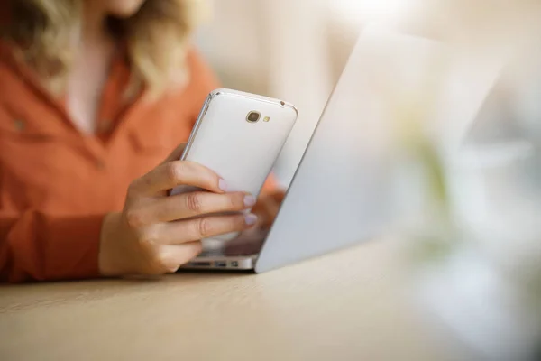 Kvinna ansluten på smartphone och laptop — Stockfoto