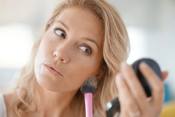 Mulher loira colocando maquiagem — Fotografia de Stock