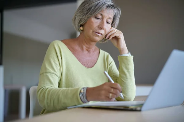 Senior vrouw thuis met behulp van laptop — Stockfoto