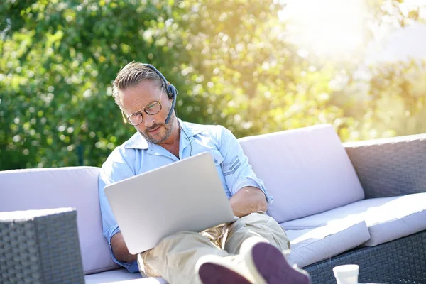 Cool Affärsman Arbetar Med Bärbar Dator Och Headset Utanför Kontoret — Stockfoto