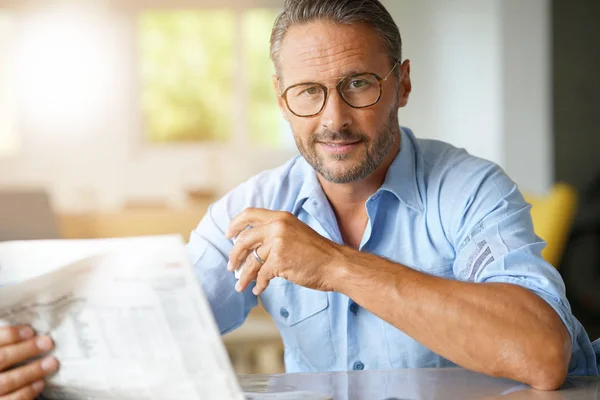 Mannen med glasögon läsa tidningen — Stockfoto