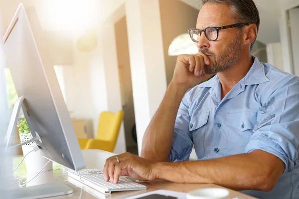 Älterer Mann arbeitet von zu Hause aus — Stockfoto