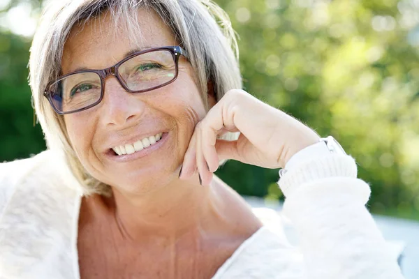 Mujer con gafas que se relaja afuera — Foto de Stock