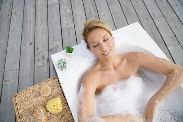 Woman relaxing in outdoor bathtub — Stock Photo, Image