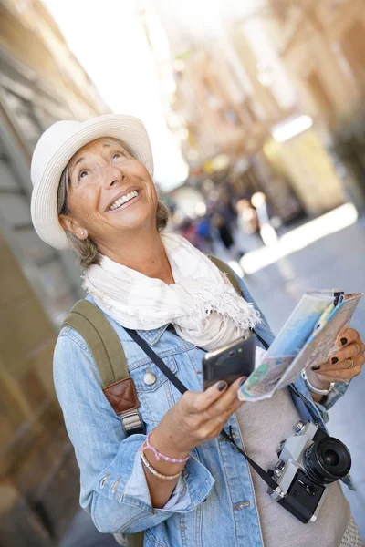 Femme utilisant smartphone et carte — Photo