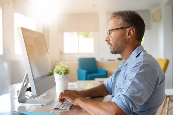 Älterer Mann arbeitet von zu Hause aus — Stockfoto