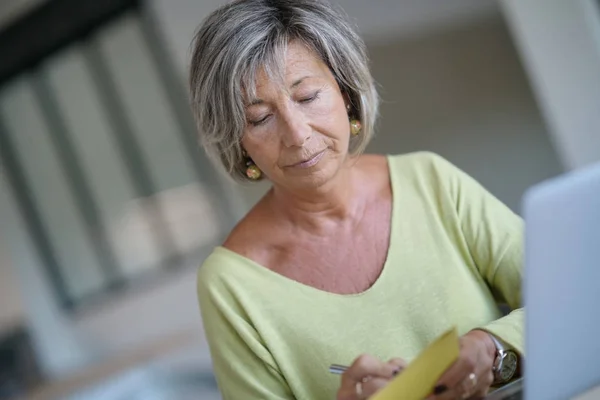 Senior Kobieta w domu za pomocą laptopa — Zdjęcie stockowe