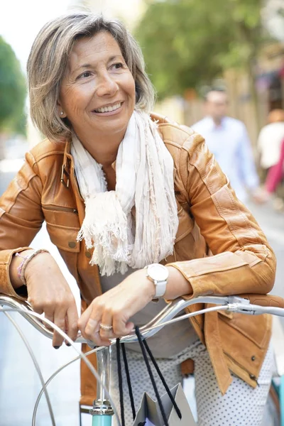 Mujer mayor montar bicicleta de la ciudad — Foto de Stock