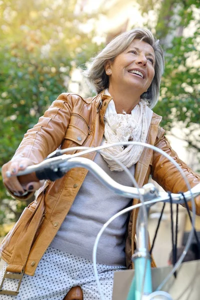 Старшая женщина на велосипеде города — стоковое фото