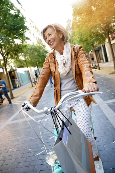 Anziano donna equitazione city bike — Foto Stock