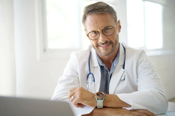 Lekarz siedzi w gabinecie lekarskim — Zdjęcie stockowe