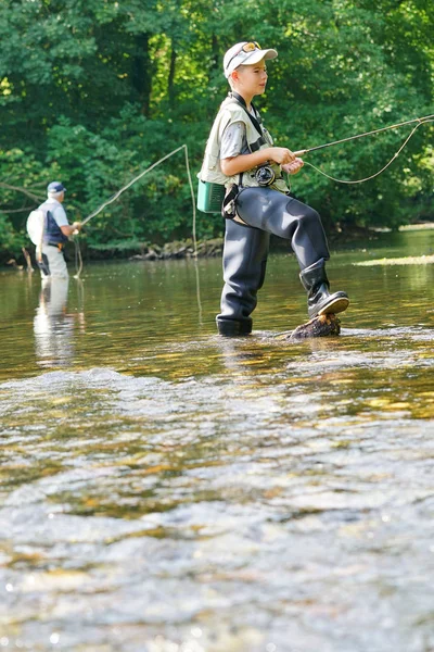 Jeune garçon mouche pêche dans la rivière — Photo