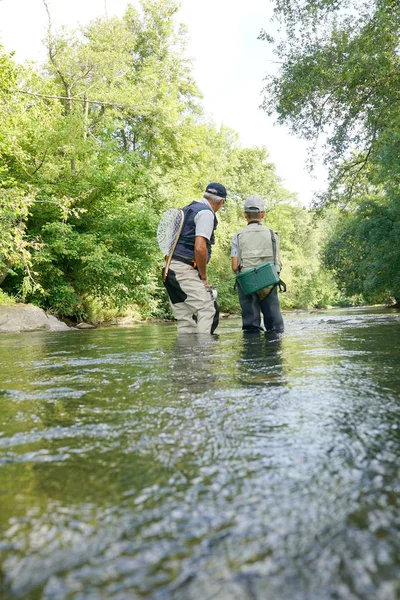 Отец и сын рыбачат в реке — стоковое фото