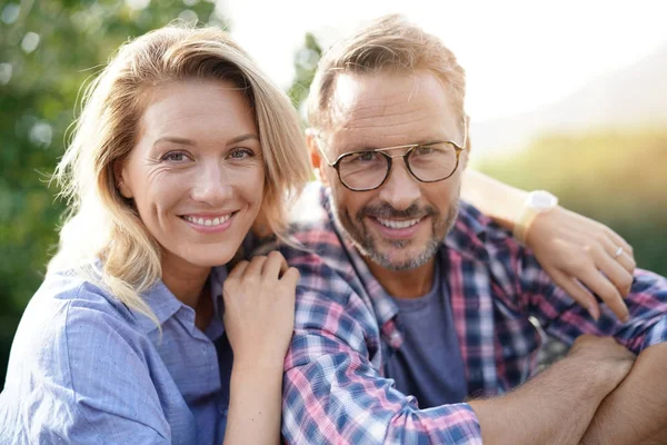 Couple relaxing on outdoor sofa — Stock Photo, Image