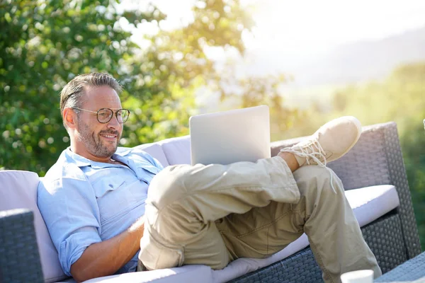 Sorrindo homem maduro usando laptop — Fotografia de Stock