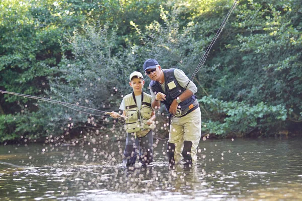 Father teaching son how to fly-fish — Stock Photo, Image