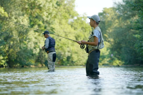 Giovane ragazzo pesca a mosca nel fiume — Foto Stock