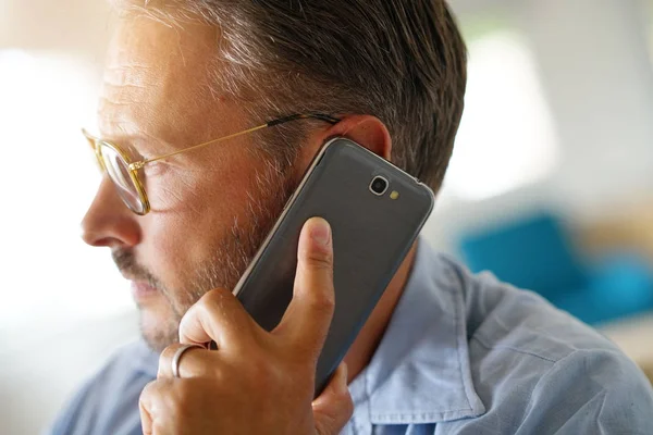 Olgun adam akıllı telefon kulağınıza tutarak closeup