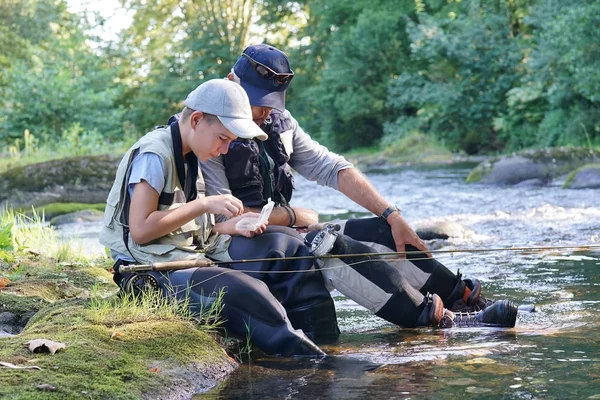 Dad helping son to choose flies — Stock Photo, Image