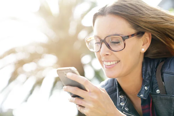 Girl in town using smartphone — Stock Photo, Image