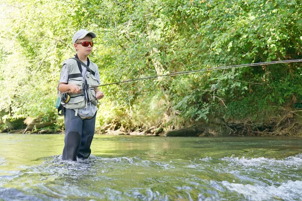 Мальчик рыбачит в реке — стоковое фото