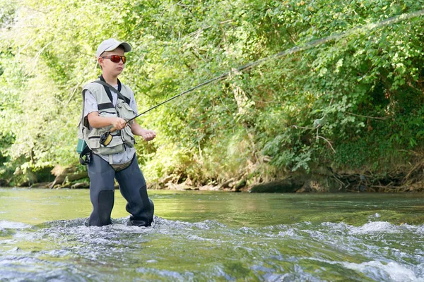 Boy fly-fishing in river — Stock Photo, Image