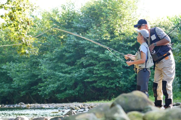 Vader zoon onderwijzen hoe te fly-fish — Stockfoto