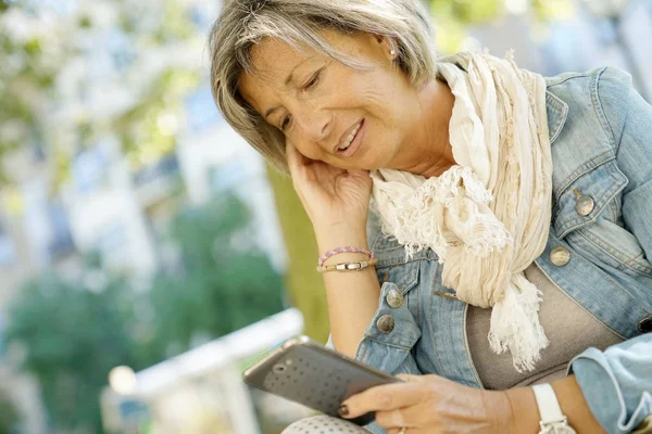 Senior woman reading message — Stock Photo, Image