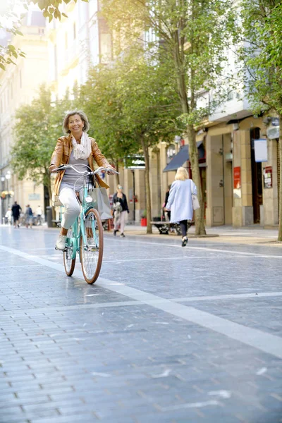 Senior woman riding city bike — Stock Photo, Image