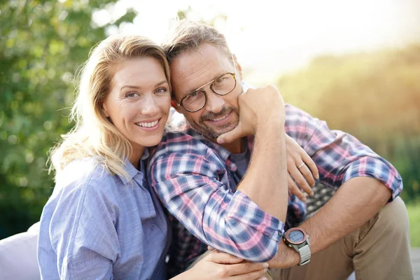 Couple relaxing on outdoor sofa — Stock Photo, Image