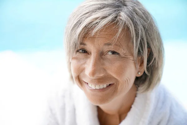 Mulher madura relaxante junto à piscina — Fotografia de Stock