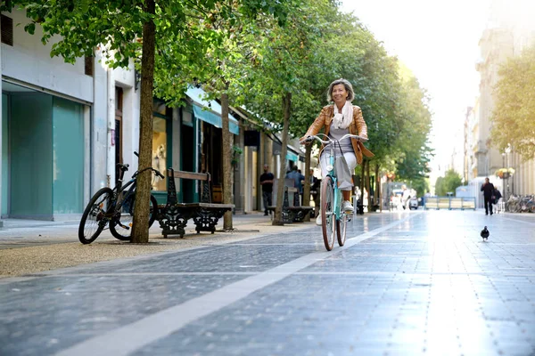 senior woman riding city bike