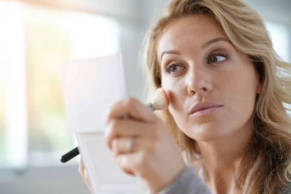 Blonde vrouw zetten make-up op — Stockfoto