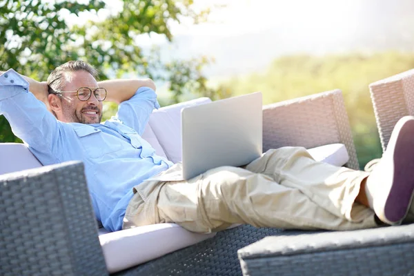 Lachende volwassen man met laptop — Stockfoto