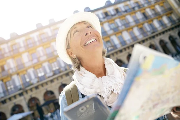 Mujer usando smartphone y mapa — Foto de Stock