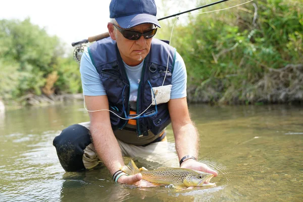 Pêcheur attrapant la truite brune — Photo