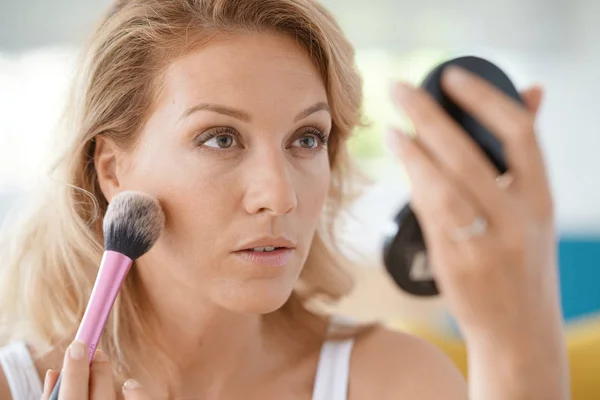 Mulher loira colocando maquiagem — Fotografia de Stock