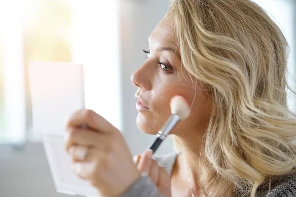 Blond woman putting makeup on — Stock Photo, Image