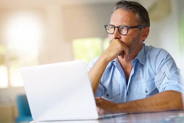 Volwassen man aan het werk op laptop — Stockfoto