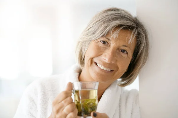 Woman in bathrobe drinking — Stock Photo, Image