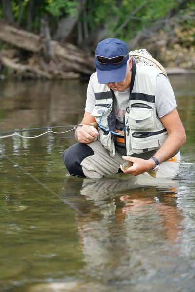 Visser proberen om vrij van bruine forel — Stockfoto