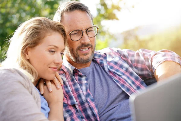 Paar entspannt auf Sofa im Freien — Stockfoto