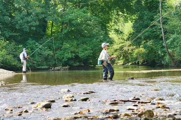 Jeune garçon mouche pêche dans la rivière — Photo