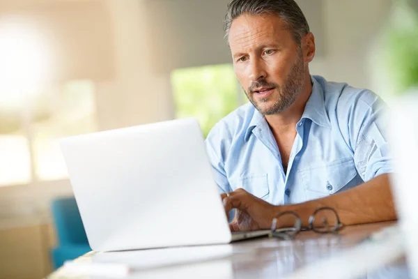 Volwassen man aan het werk op laptop — Stockfoto