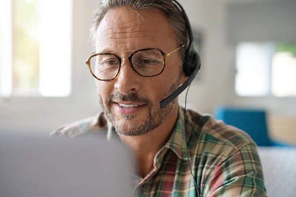 Man met bril verbonden met laptop Rechtenvrije Stockfoto's