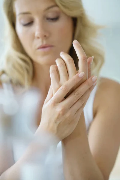 Mani di donna che applicano crema per le mani idratante — Foto Stock