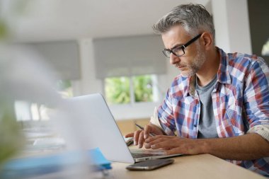 Dizüstü bilgisayarda çalışan iş adamı