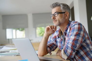 Dizüstü bilgisayarda çalışan iş adamı