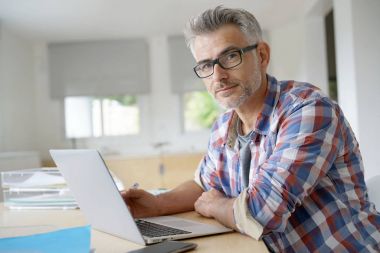 Dizüstü bilgisayarda çalışan iş adamı